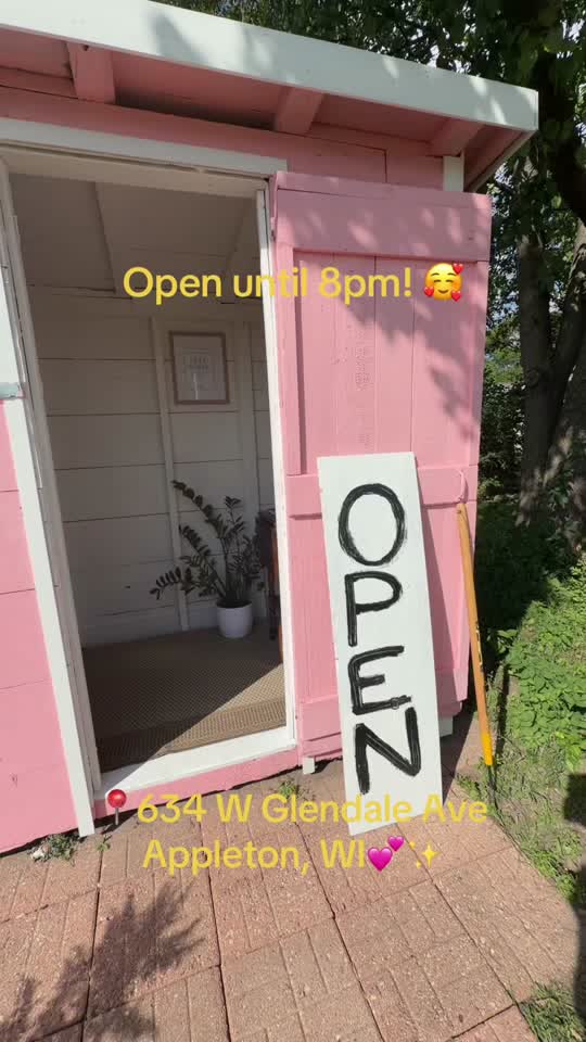 The pink farm stand with an OPEN sign outside