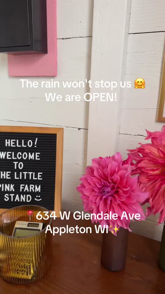 Welcome sign at The Little Pink Farm Stand with pink dahlias